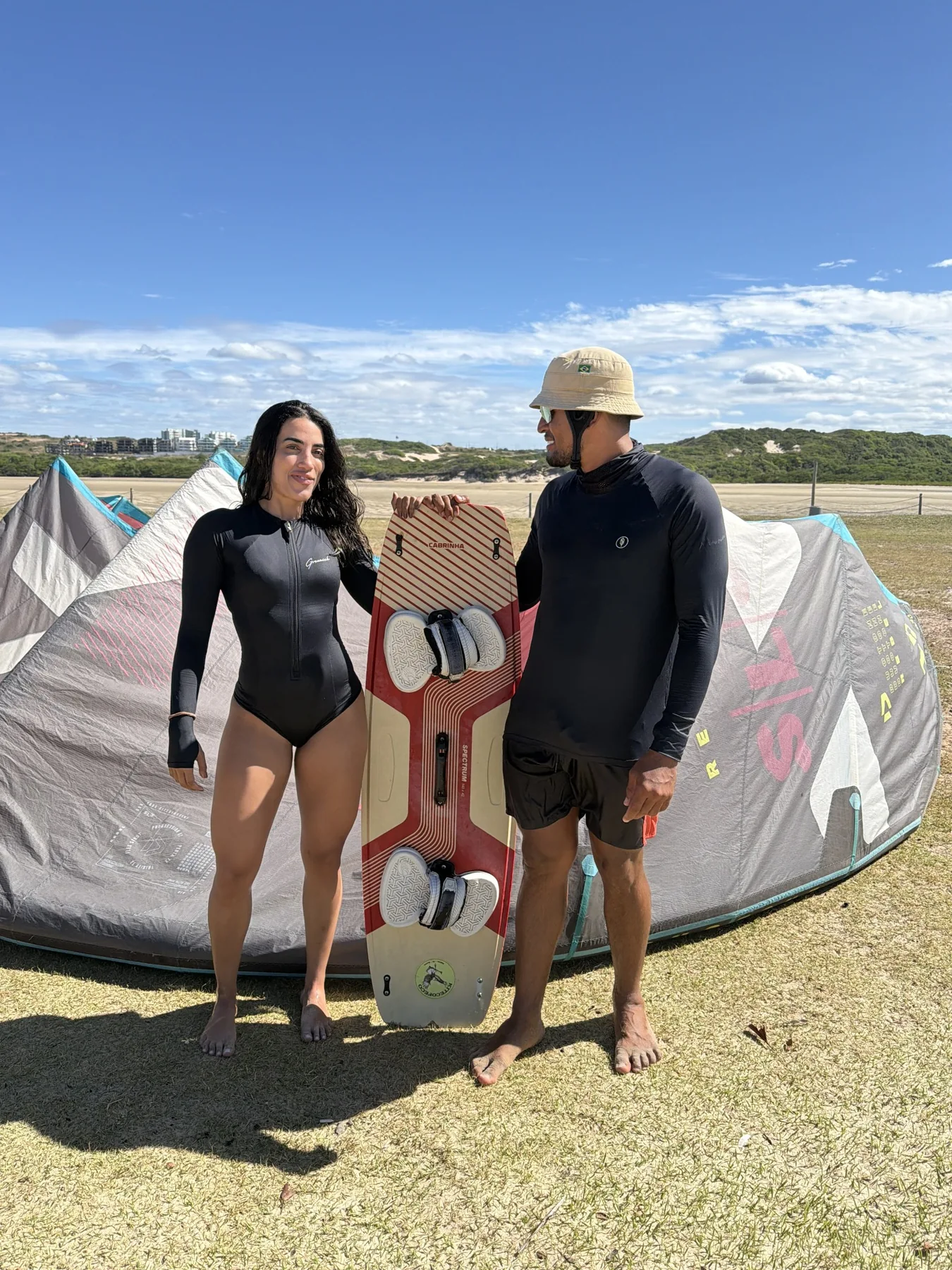 Pessoas e equipamentos de kitesurf na praia